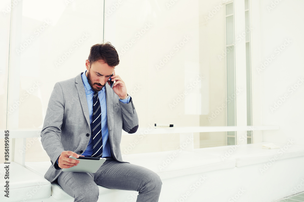 Smart male professional worker using touch pad while standing in office space Smart male professional worker using touch pad while standing in office space