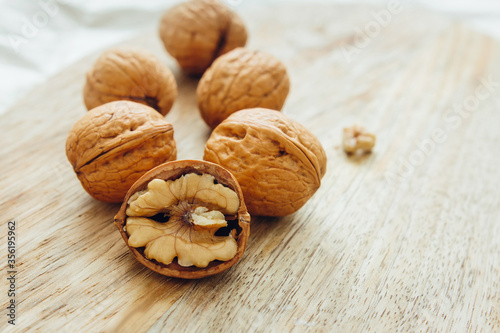 Unpeeled walnuts on wooden surface, closeup. Food photo. Selective focus.