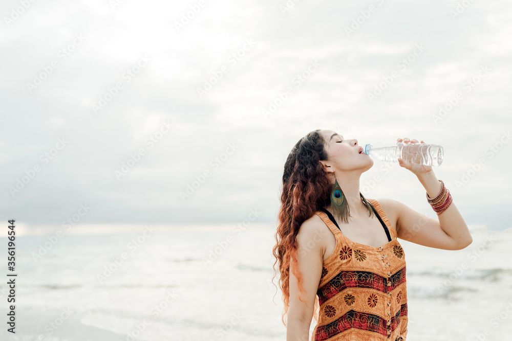 Beautiful woman standing holding a bottle of drinking water show Beautiful woman standing holding a bottle of drinking water show