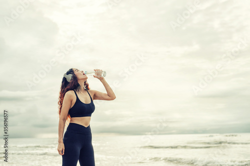 Beautiful woman standing holding a bottle of drinking water show