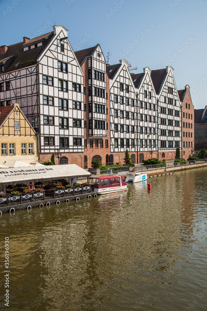 Fototapeta premium Gdansk, Poland - Juny, 2019: Motlawa river with old town architecture background in Gdansk, Poland