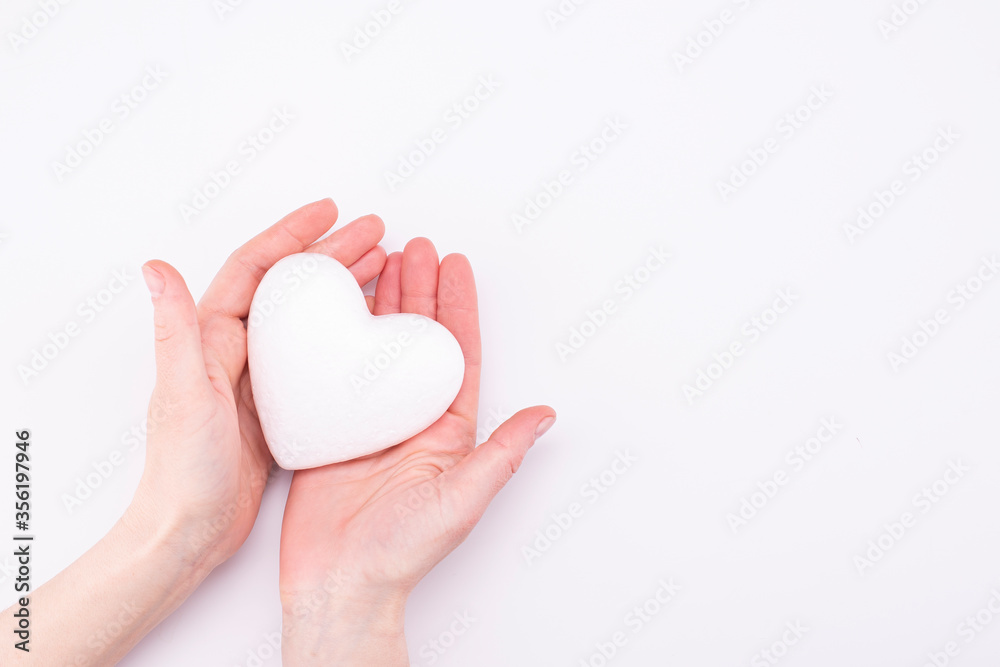 White heart in female hands isolated on white background with place for text