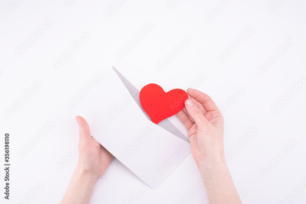 hands take out heart Valentine from white envelope on white background. declaration of love concept hands take out heart Valentine from white envelope on white background. declaration of love concept