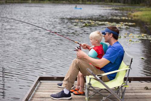 Father and son fishing on dock at Moose Creek Reservoir in northern Idaho, USA photo