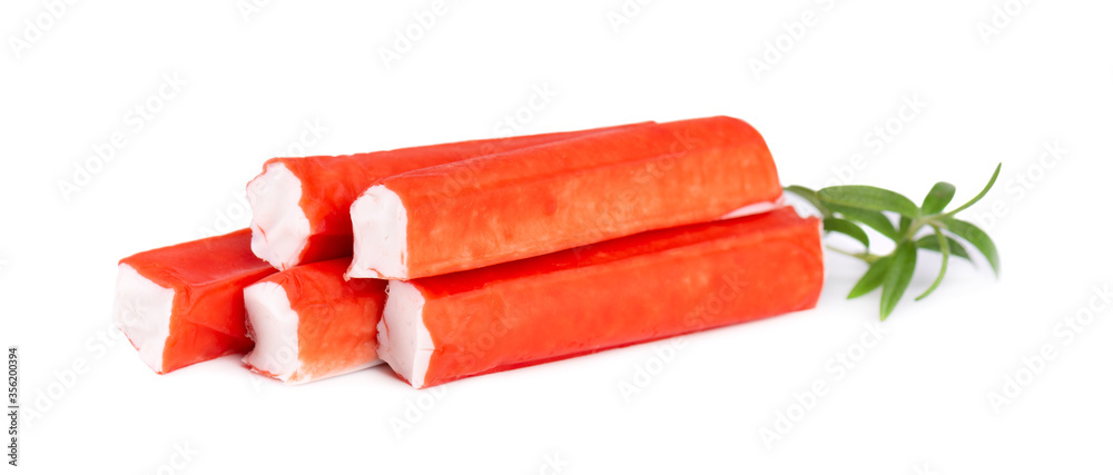 Crab stick isolated on white background. Imitation crab meat with rosemary sprig. Fish product. Crab stick isolated on white background. Imitation crab meat with rosemary sprig. Fish product.