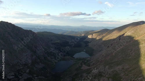 Aerial shot of lake in valley amidst mountains against sky, drone flying over natural landscape - Mount Evans, Colorado photo