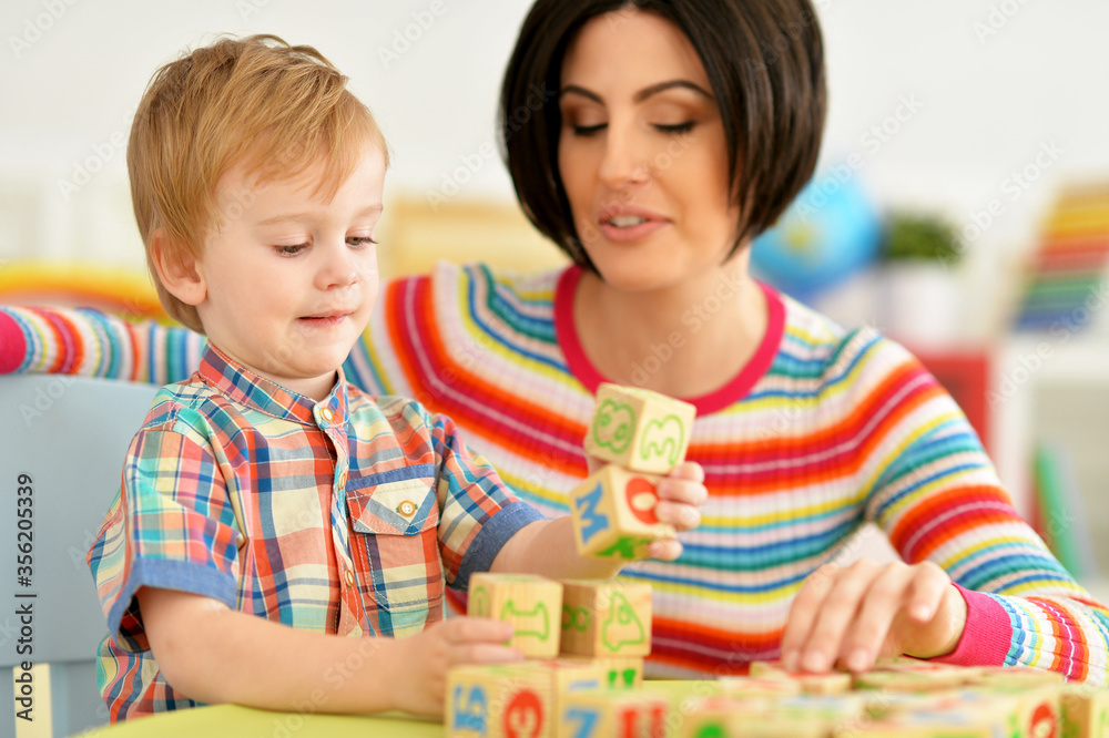 Fototapeta premium Woman and little boy playing with cubes