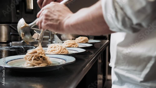 MS Chef putting servings of spaghetti on plates / Florence, Tuscany, Italy