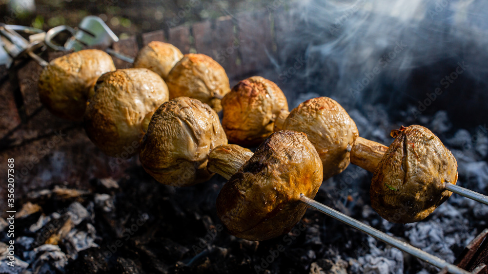 Appetizing mushrooms are grilled. Vegan shish kebab.