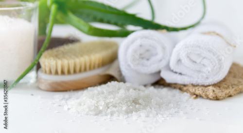 Eco set for spa treatments at home with towels, pumice, salt, candle on a white background.