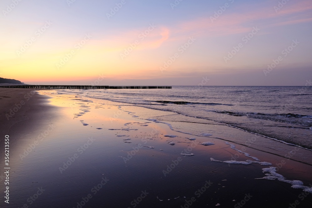 Beautiful sunset colors on the beach of sea and amazing reflection in water.