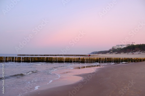Fototapeta Naklejka Na Ścianę i Meble -  Beautiful sunset colors on the beach of sea. Silhouette of walking person.