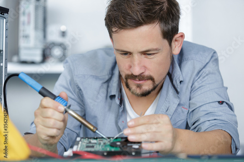 computer specialist soldering a pc part