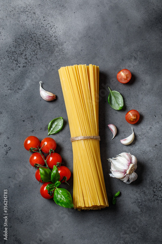 Raw spaghetti on rustic background. Ingredients for pasta