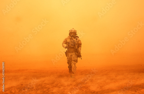 Military soldier between storm and dust at desert photo