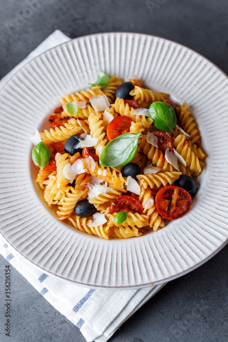 Pasta fusilli with cherry tomatoes, basil and olives. Homemade pasta 