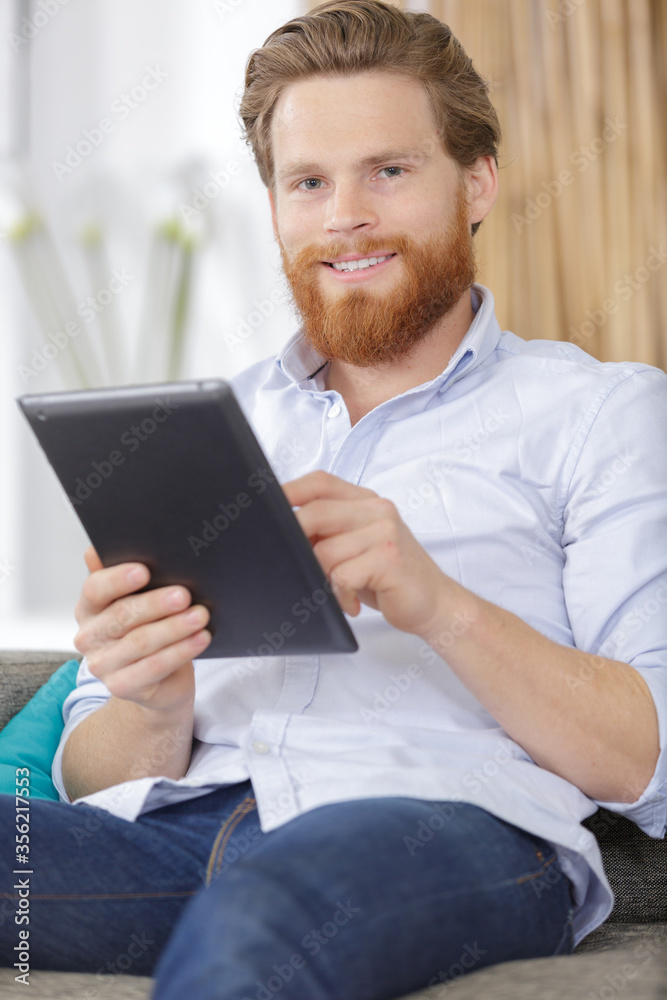 bearded man at home using tablet bearded man at home using tablet