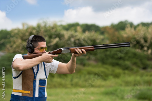 Quadro em tela Man shooting skeet with a shotgun. Skeet shooting, trap shooting.