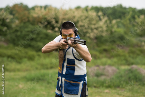 Man shooting skeet with a shotgun. photo