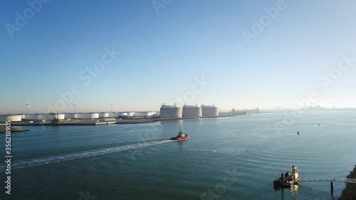 WS POV Tugboat next to oil storage and LNG containers in Tweede Maasvlakte, part of Rotterdam harbour / Rotterdam, Zuid-Holland, Netherlands photo