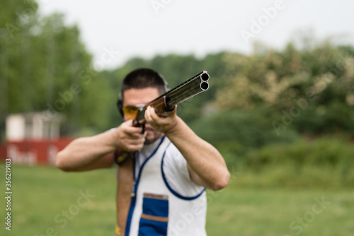 Man shooting skeet with a shotgun.