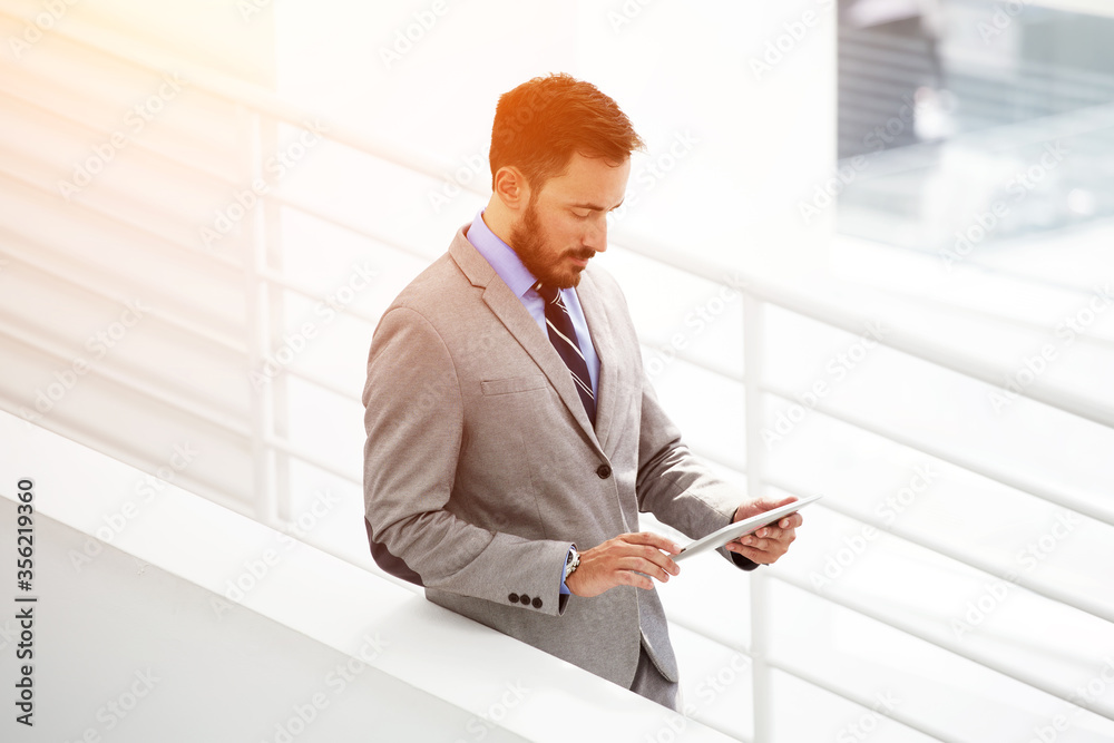 Male intelligent CEO is waiting business partners in hallway his company Male intelligent CEO is waiting business partners in hallway his company