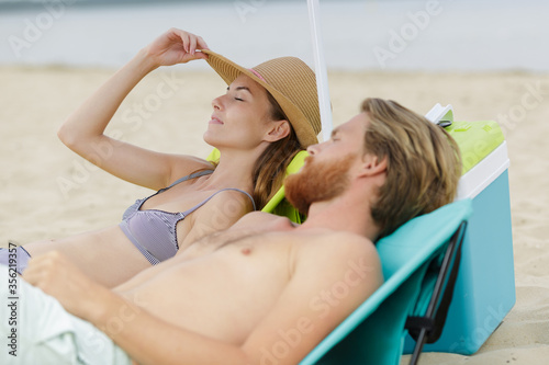 unknown couple on vacation relaxing in their beach chairs