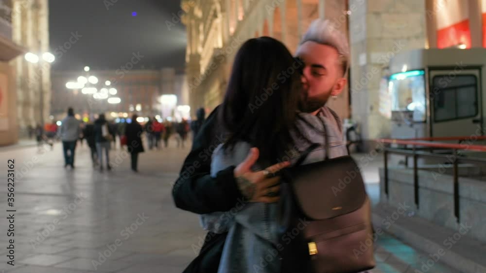 MS Couple embracing and spinning in town square / Milan, Italy