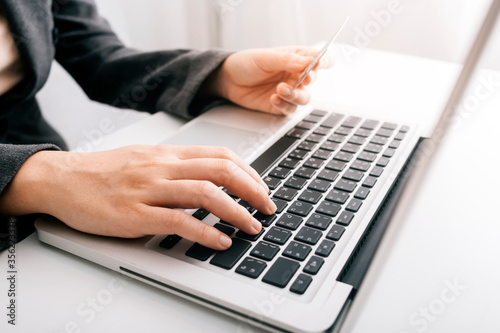 businesswoman hand using smart phone,tablet payments and holding credit card online shopping,omni channel,digital tablet docking keyboard computer at office in sun light