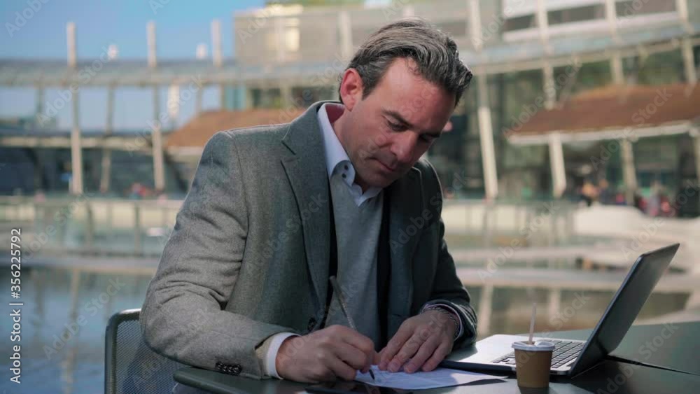 MS Businessman working in sidewalk cafe in business district / Milan, Italy MS Businessman working in sidewalk cafe in business district / Milan, Italy