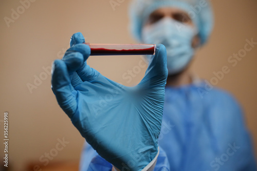 The concept of preventing the spread of the epidemic and treating coronavirus. The doctor points to a test tube with a blood test. Coronavirus treatment. Doctor.