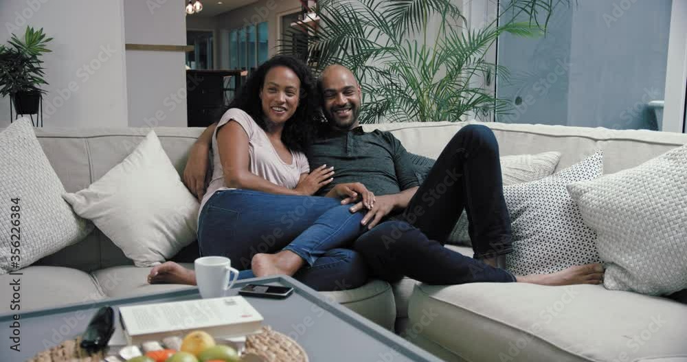 MS PAN Couple reclining on sofa in living room / Claremont, Cape Town, South Africa MS PAN Couple reclining on sofa in living room / Claremont, Cape Town, South Africa
