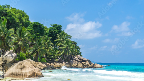 Panoramic view of nice tropical sandy beach with famous granite rocks on, La Digue Island, Seychelles. Holiday and vacation concept. Tropical beach on background blue sky © mathilde