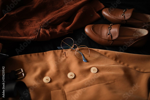 Composition from clothes. Shirts and a jacket with loafers on a dark background. Clothing. 