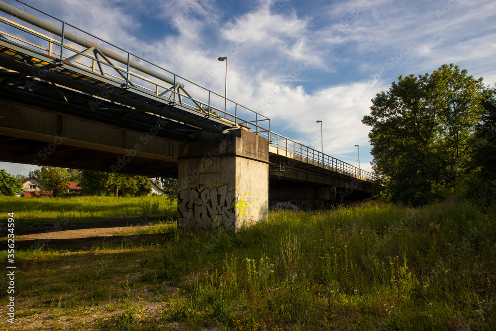 Old, graffiti sprayed and rusty bridge crossing Sava river in Podsused, suburb of Zagreb city, photographed at sunset from the river shore Old, graffiti sprayed and rusty bridge crossing Sava river in Podsused, suburb of Zagreb city, photographed at sunset from the river shore