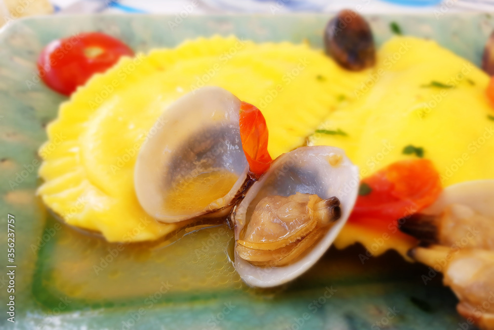 Italian Pasta, ravioli, with clams. Seasoned with olive oil, parsley and tomato Italian Pasta, ravioli, with clams. Seasoned with olive oil, parsley and tomato