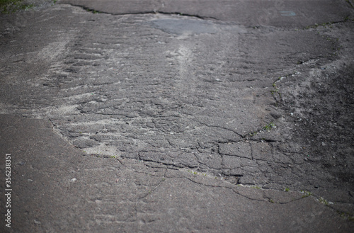 Broken asphalt and cracks on the road surface