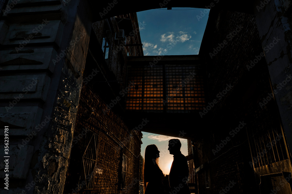 Romantic couple kissing in the city. Silhouette couple kissing over sunset background.