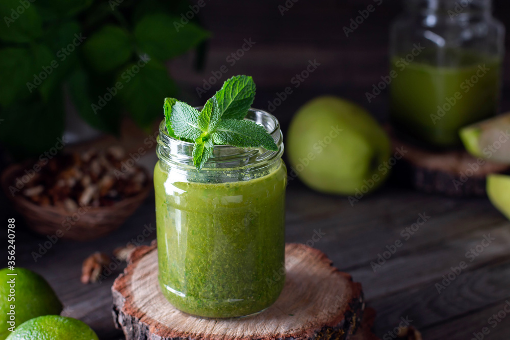 Fresh green smoothie on rustic wooden background