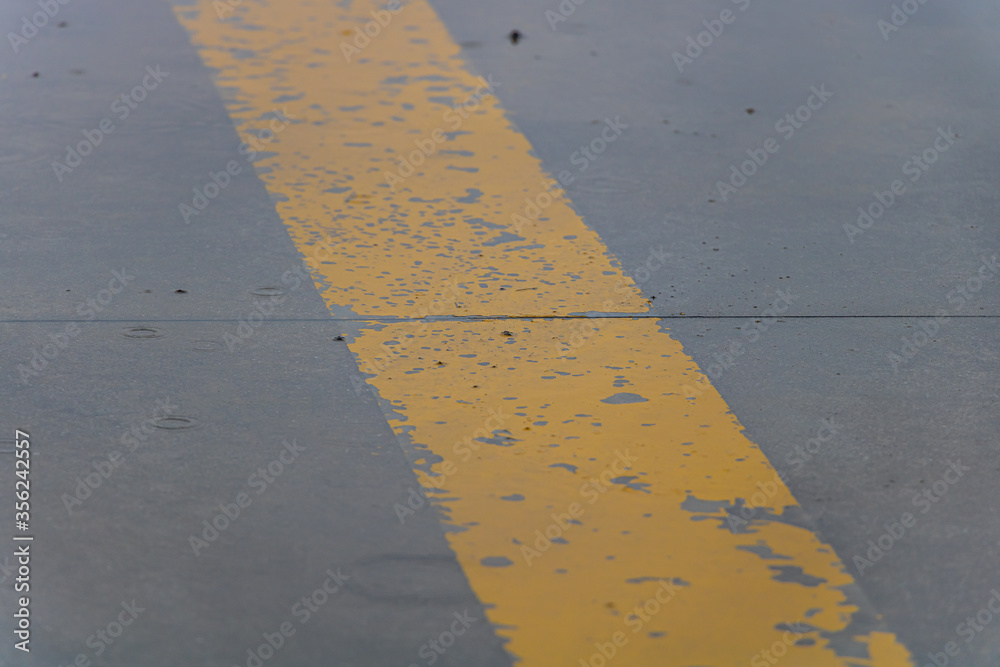 Fototapeta premium Yellow Strip on Grey Concrete During Rain Day
