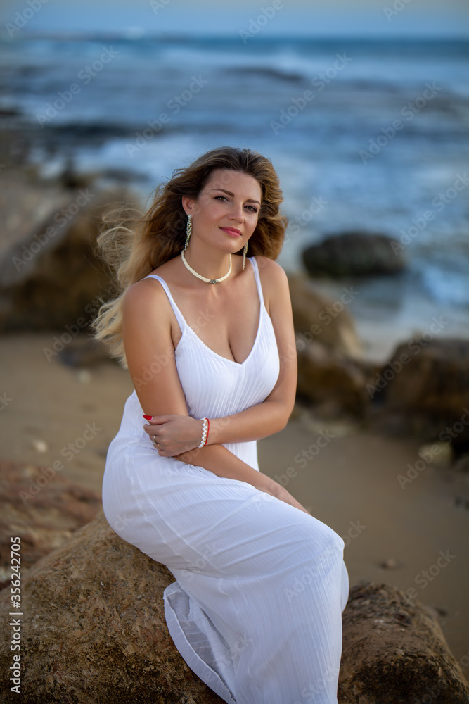 Beautiful woman sitting near the sea Beautiful woman sitting near the sea