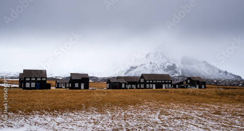 Cabin houses and the snowcapped stapafel mountain Hellnar, Snaefellnes peninsula Iceland photo