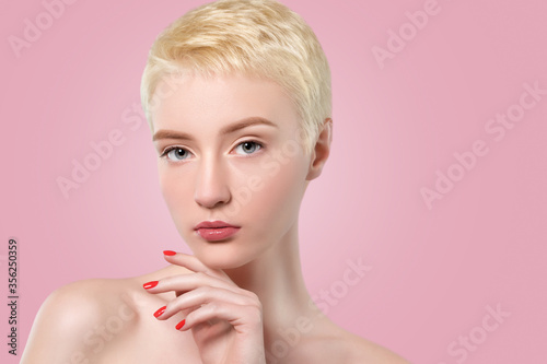 Portrait of a beautiful woman with short blonde hair, beautiful fresh make-up and with healthy clean skin on a pink background. Make-up and cosmetology concept.