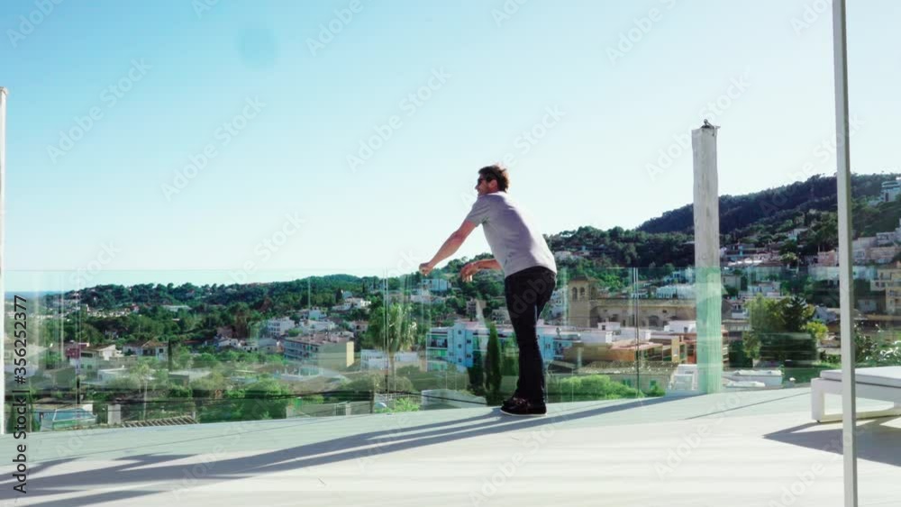 WS PAN Man standing on terrace and looking at view WS PAN Man standing on terrace and looking at view