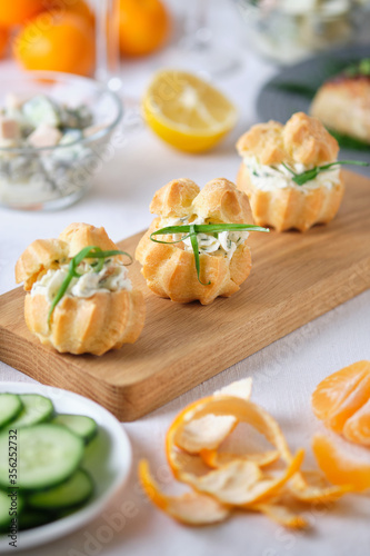 Profiteroles with soft cheese, red fish and herbs. Gourmet meal on the holiday table.