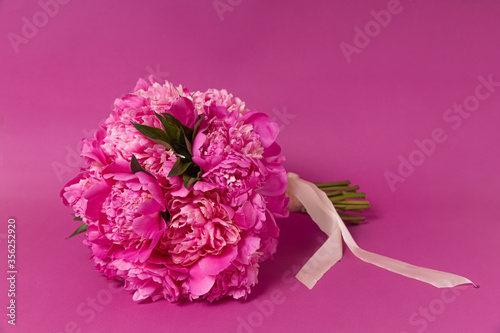 bouquet of pink peonies on a pink background