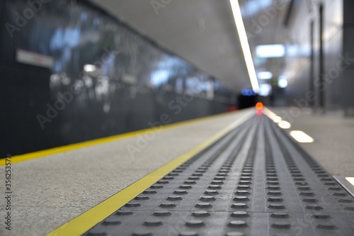 Concrete tactile strips with an yellow line - for visually impaired (handicapped) and people with blindness - on an underground station