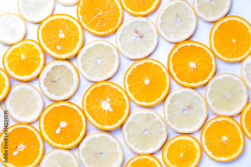 Flat lay view of orange and lemon slices on white backround.