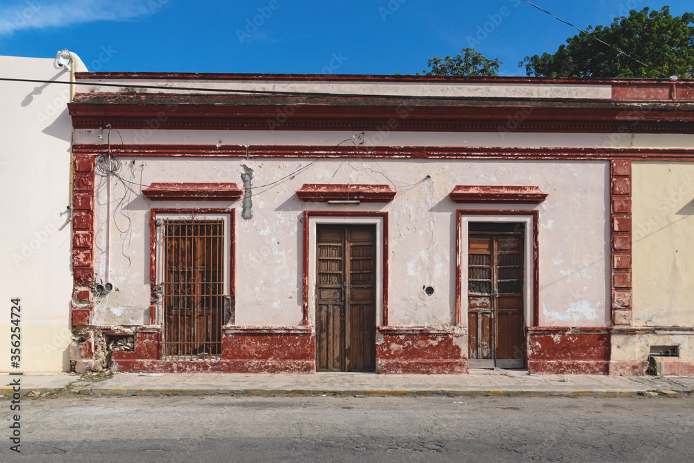 Facade of typical Mexican colonial building with wooden doors in Merida, Yucatan, Mexico