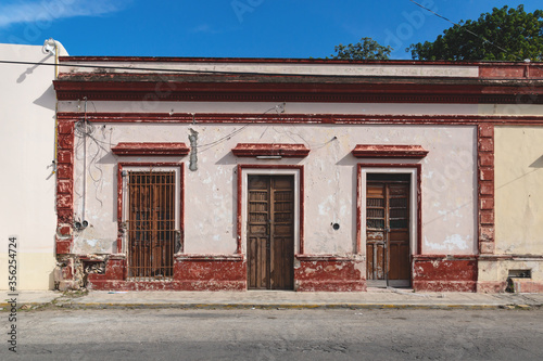 Facade of typical Mexican colonial building with wooden doors in Merida, Yucatan, Mexico